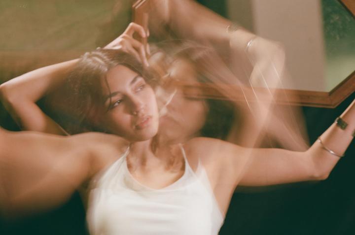 A woman with her arms raised is captured with motion blur, creating a dreamy effect.