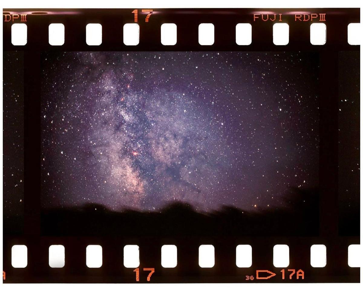 The Milky Way is visible in the night sky above a dark, undulating horizon.