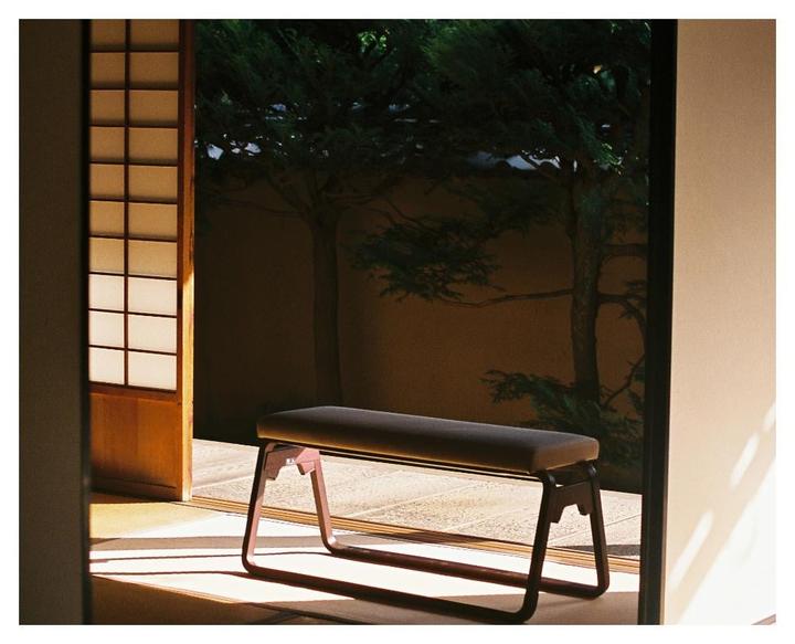 A bench sits on a tatami mat floor next to an open shoji screen, with a tree visible outside.