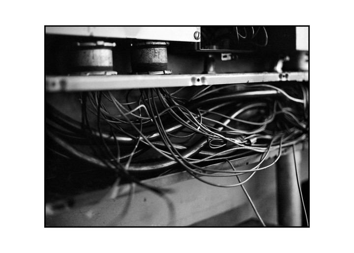 A tangle of wires and cables is visible beneath a metal shelf.