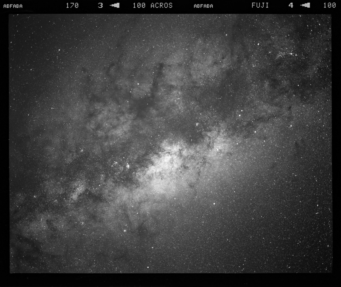 The Milky Way core is visible in a black and white astrophotography image.