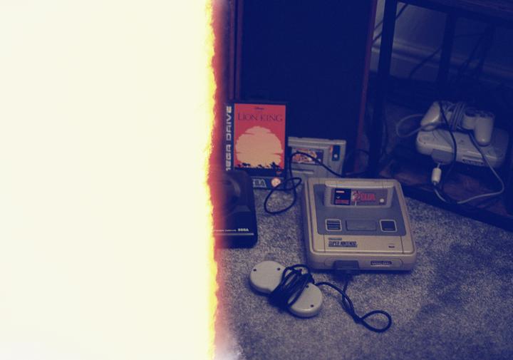 A collection of vintage video game consoles and cartridges are arranged on a carpeted floor next to a bright light leak.