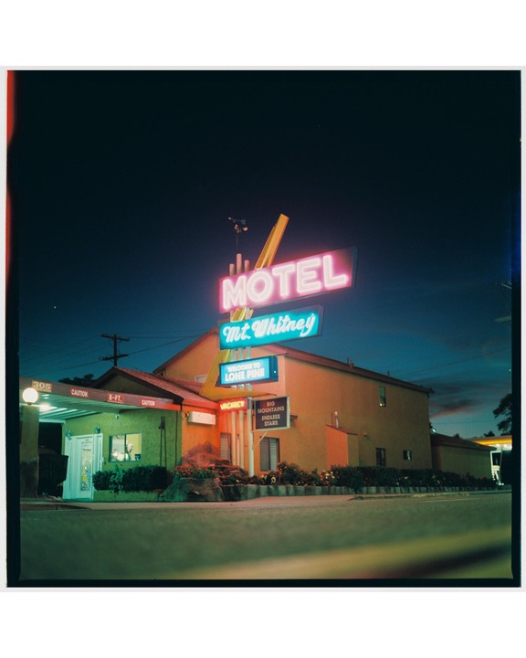 A neon motel sign for Mt. Whitney Motel in Lone Pine, California glows at night.