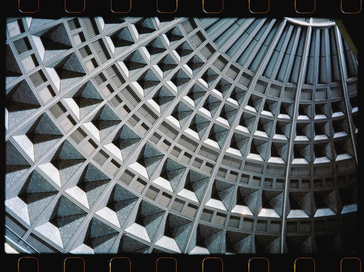 A detailed view of the geometric pattern on the ceiling of a building is shown.