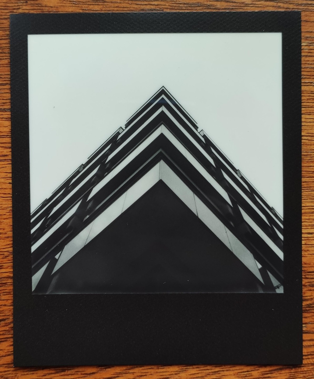 A low-angle view of a brutalist building shows its sharp angles and geometric patterns against a bright sky.