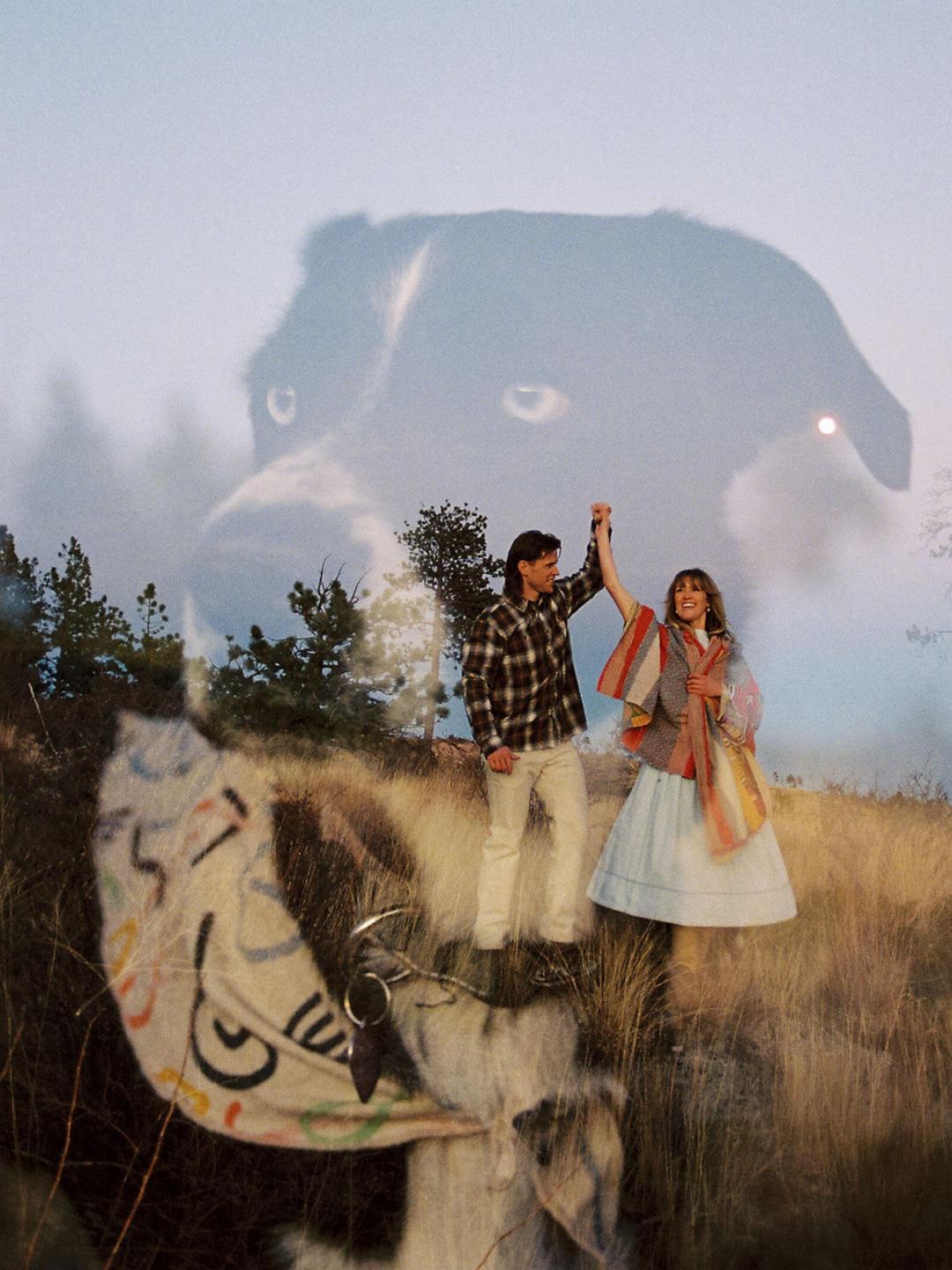 A man and woman stand in a field with a double exposure of a dog's head and a goat.