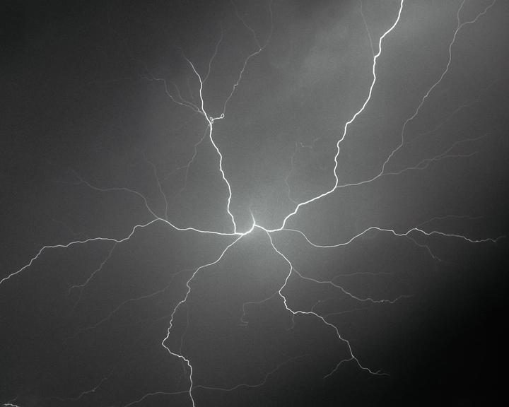 A bright bolt of lightning branches across a dark sky.