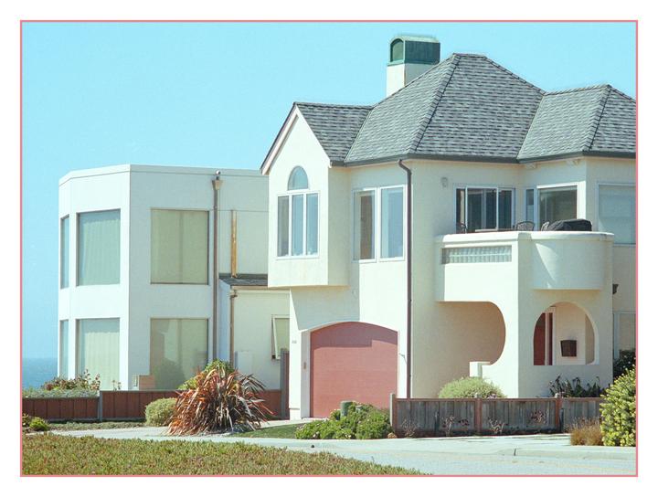 Two houses with different architectural styles are visible from the street.