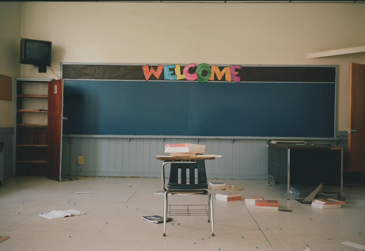 A classroom with a chalkboard, a desk, and a "WELCOME" sign is shown.