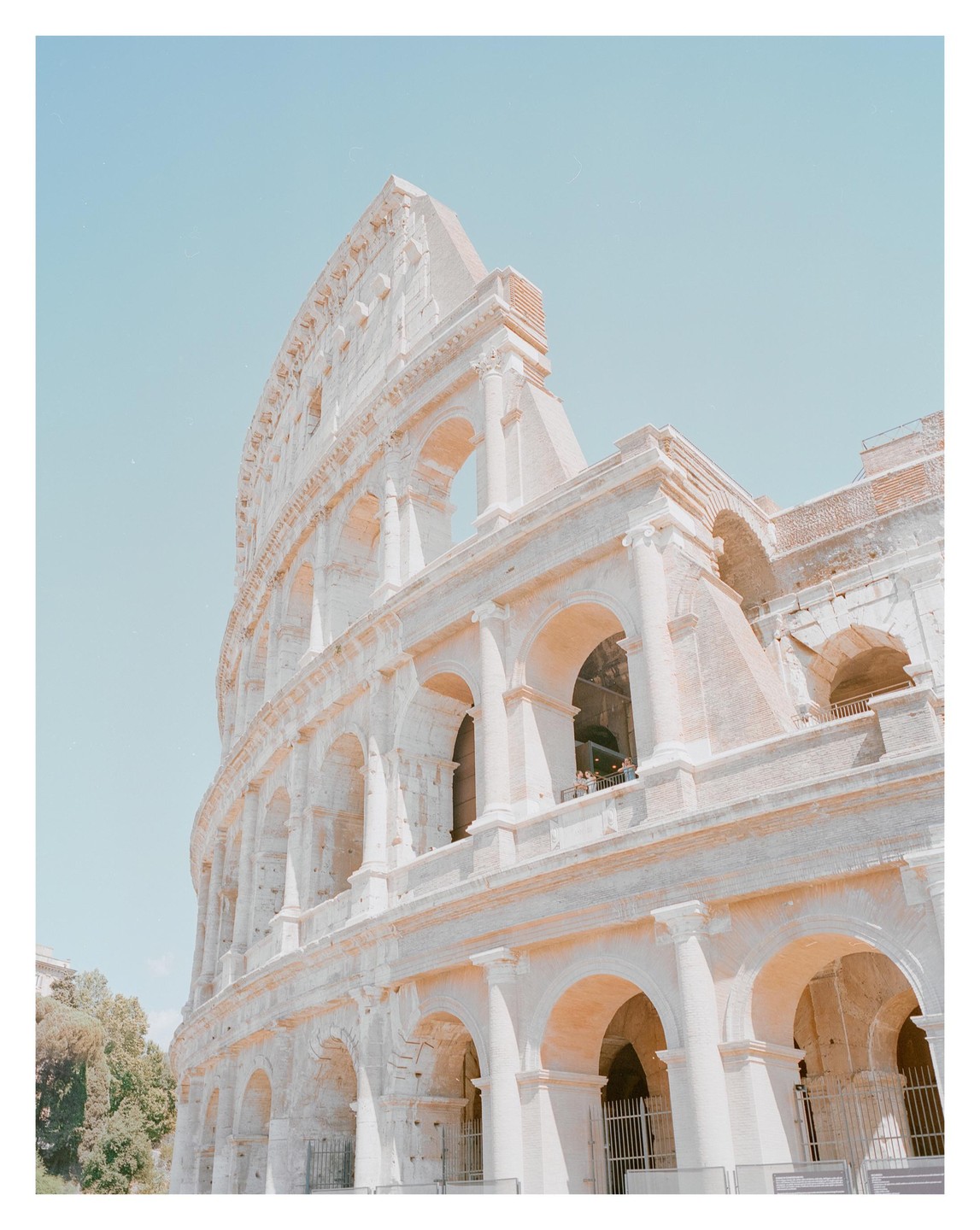 The Colosseum in Rome is shown from a low angle against a clear sky.
