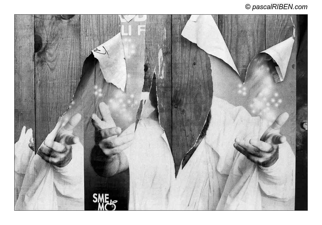 A torn poster on a wooden wall shows hands reaching out with glowing patterns and text.