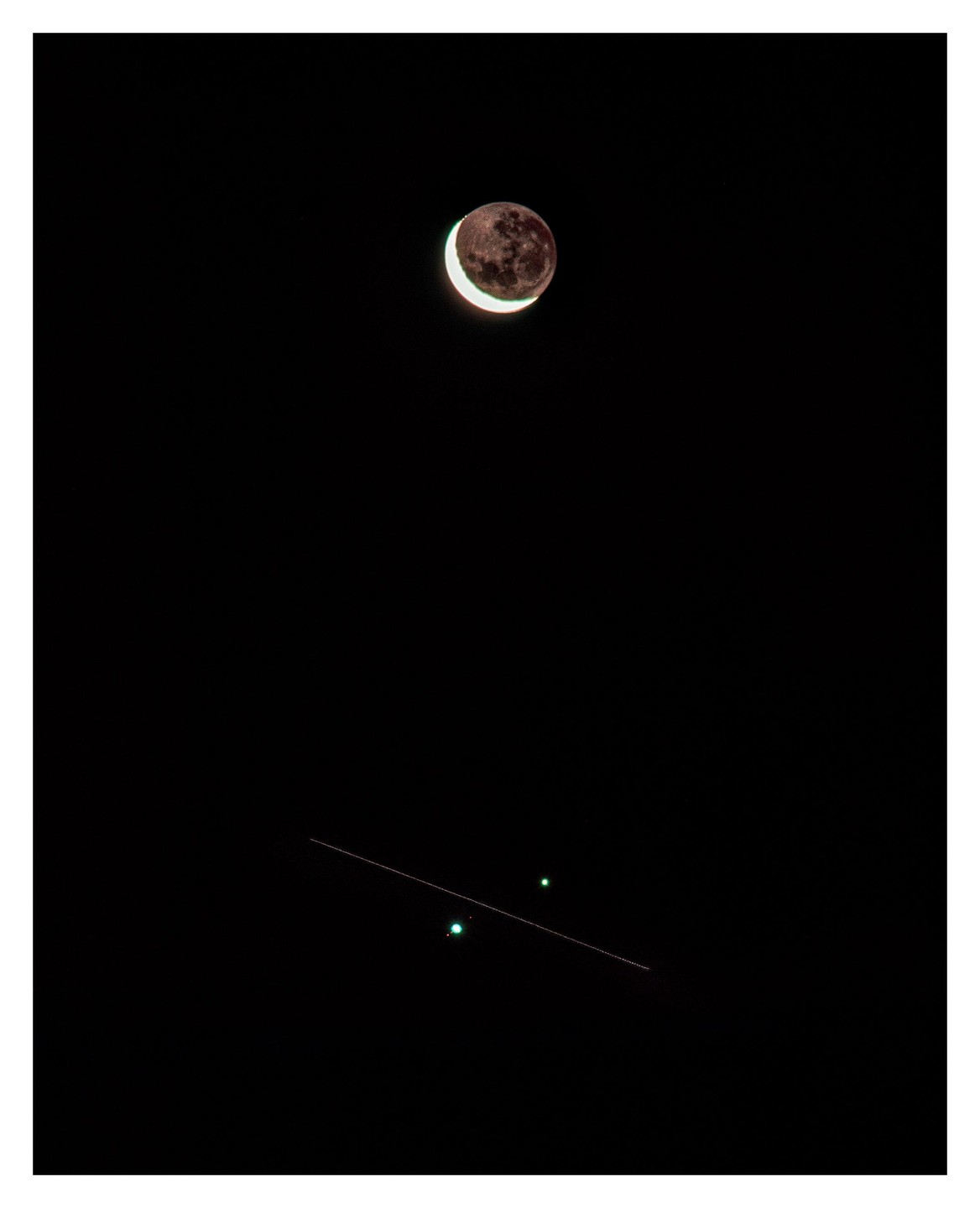 A crescent moon is visible in the night sky above a faint line and two green lights.