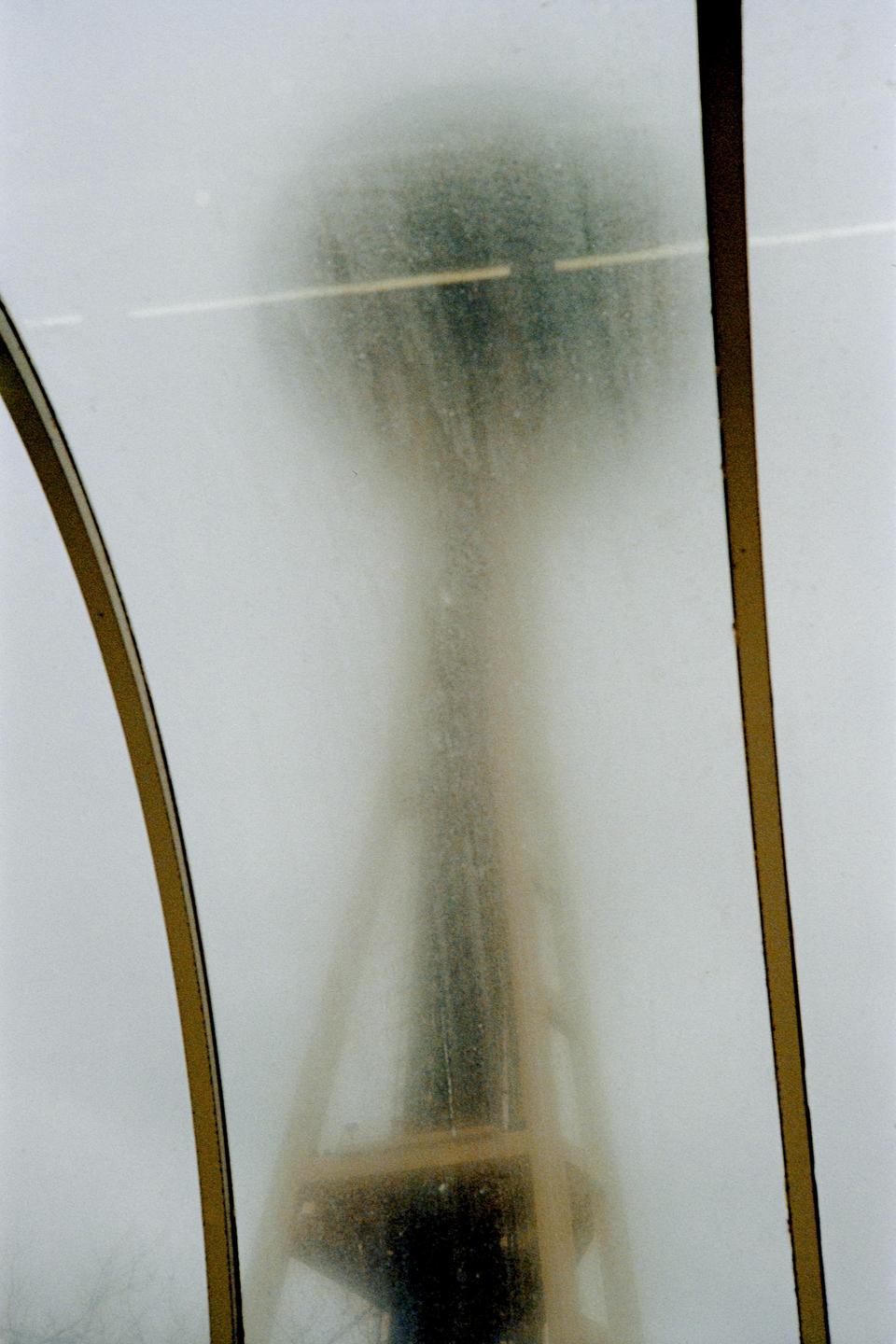 The Space Needle is visible through a dirty window.