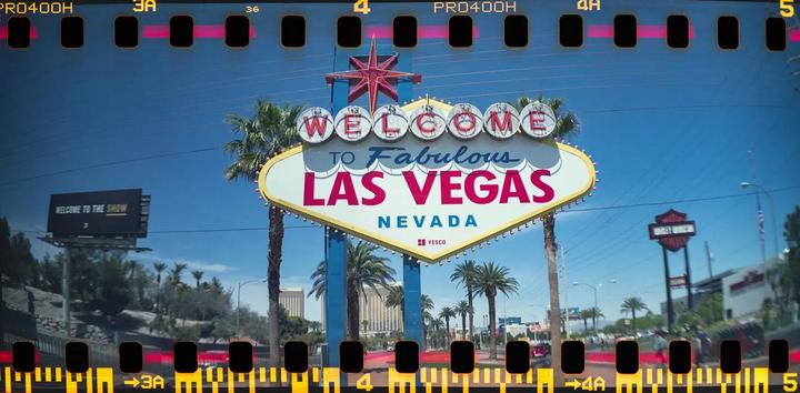 The Welcome to Fabulous Las Vegas sign stands prominently with palm trees and a clear blue sky in the background.