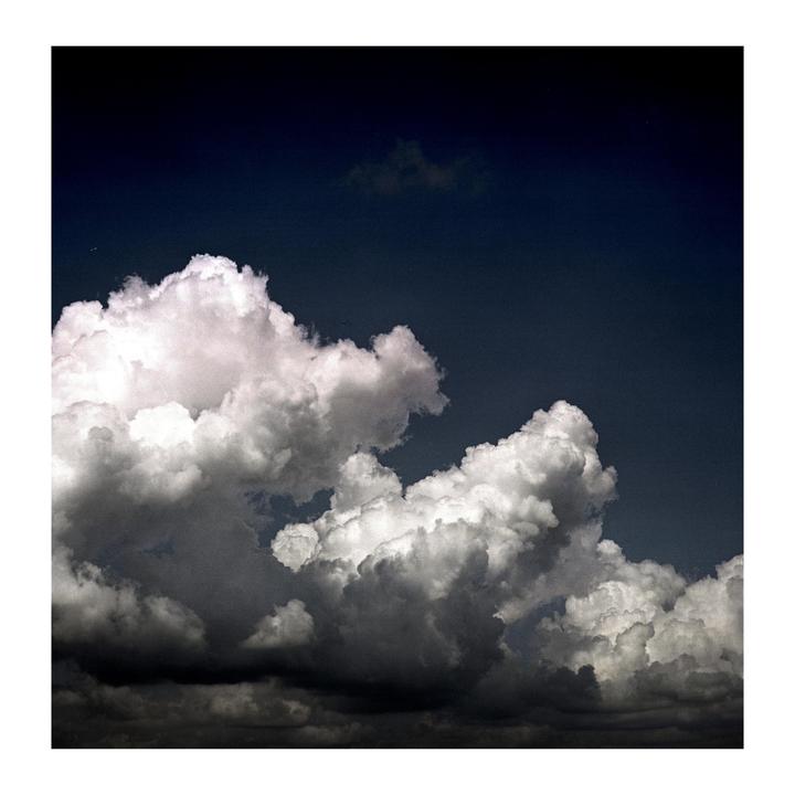 A dark sky is filled with large, dramatic clouds.