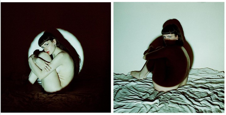 A woman sits on a bed in two self-portraits, one lit by a circular spotlight and the other by a green light.