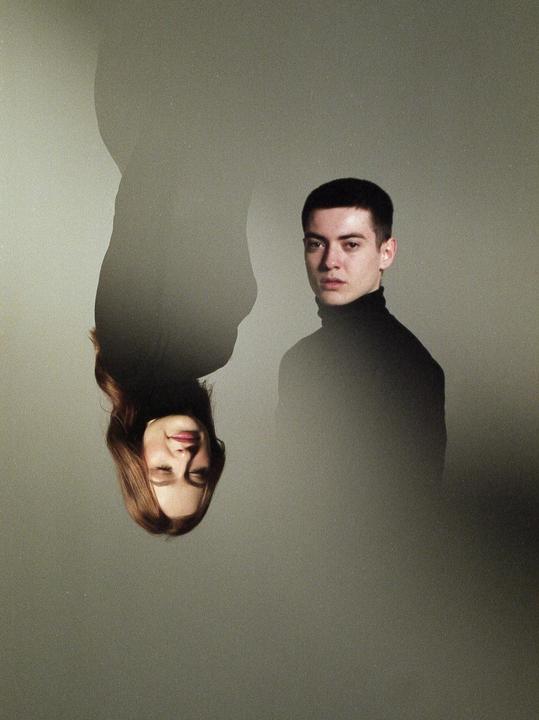 A man and an upside-down woman are visible in a double exposure portrait.