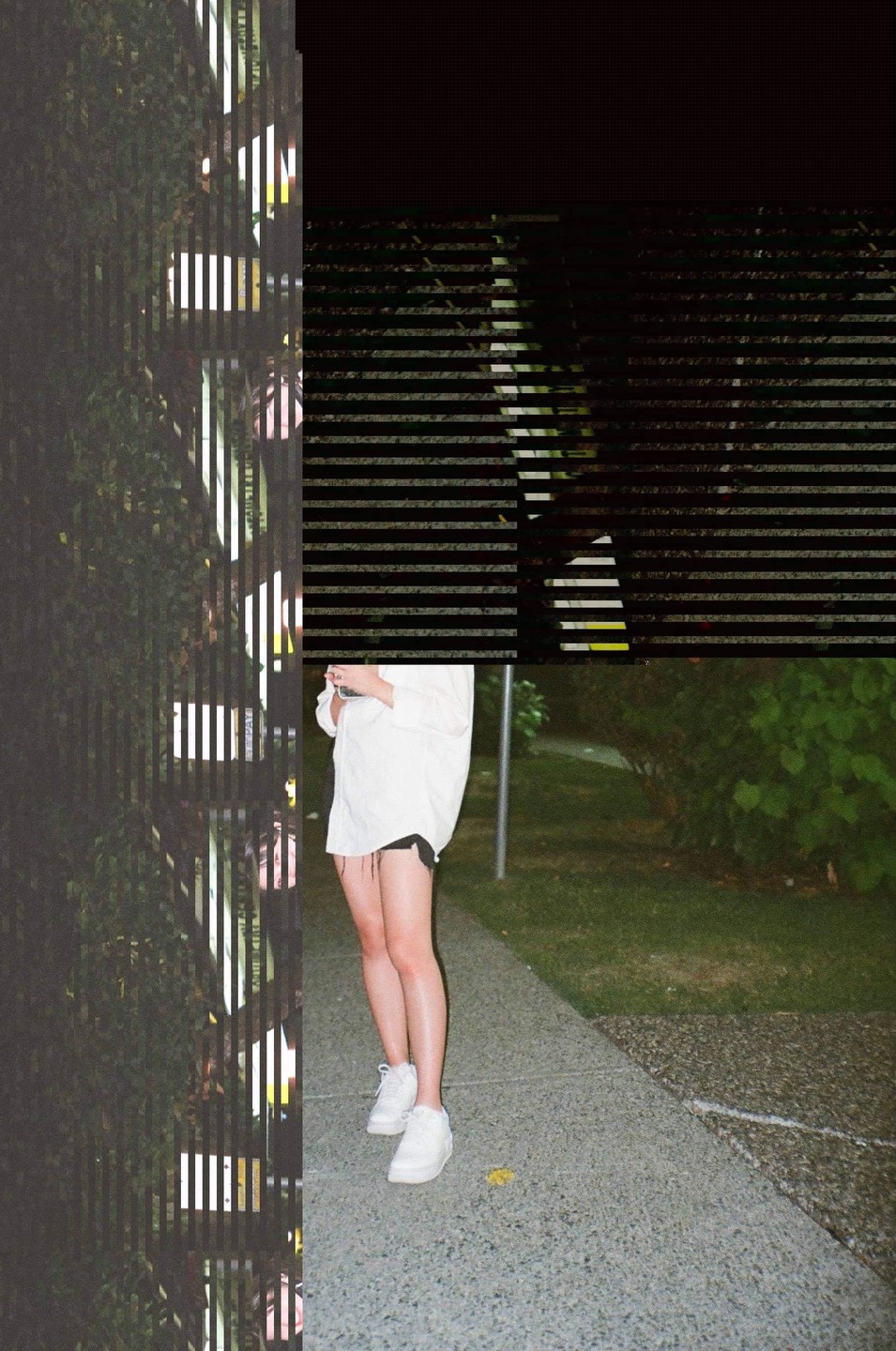 A woman stands on a sidewalk next to a grassy area, with vertical and horizontal stripes obscuring parts of the image.