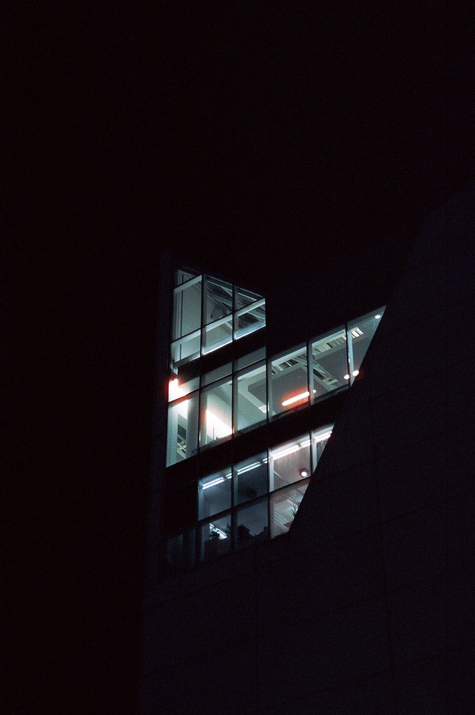 A dark building with illuminated windows is visible at night.