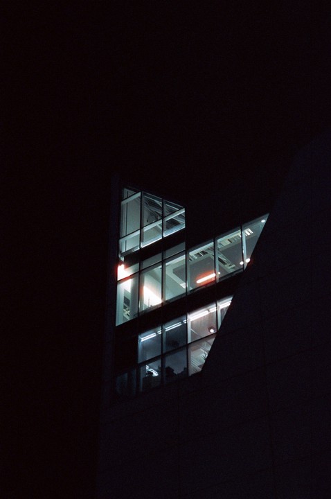 A dark building with illuminated windows is visible at night.