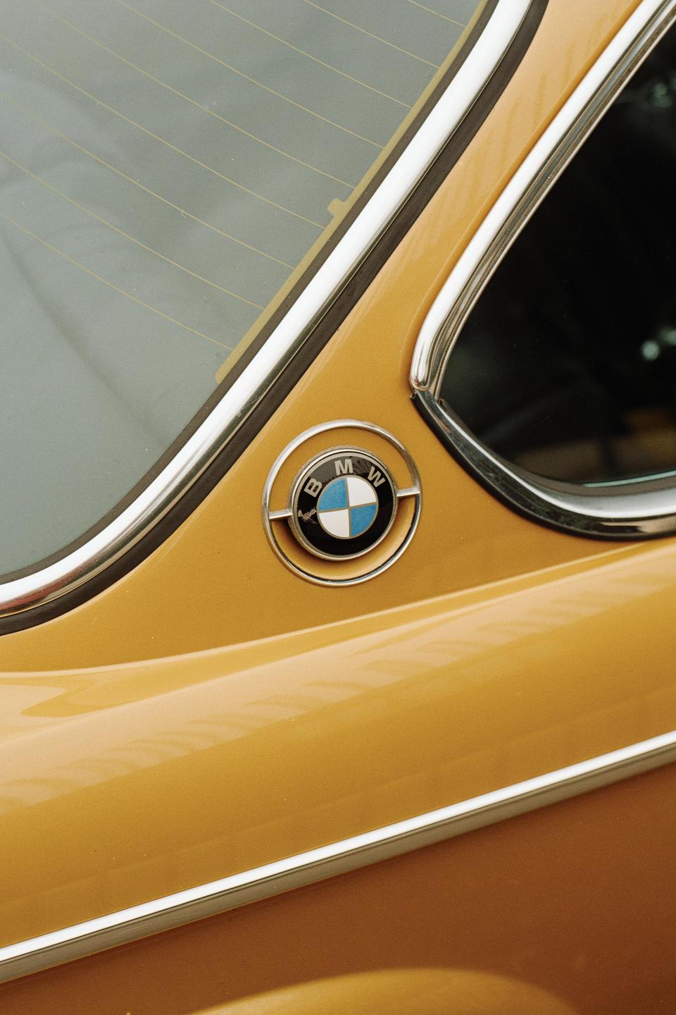 The BMW emblem is visible on the side of a gold vehicle.