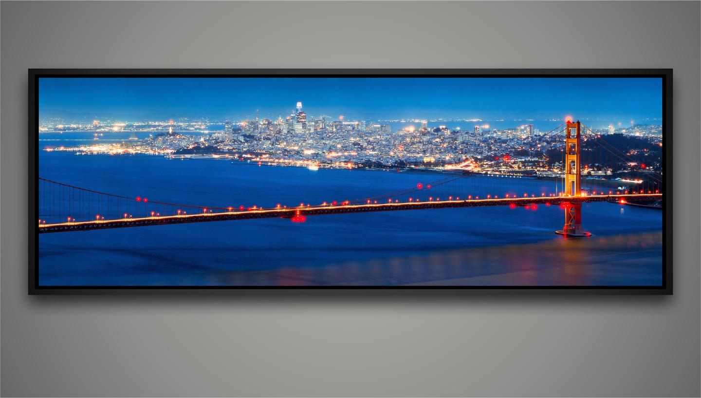 The Golden Gate Bridge is illuminated at night with the San Francisco skyline in the background.