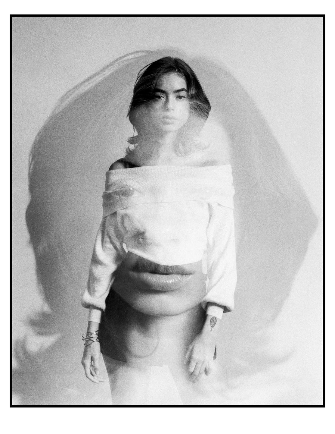 A woman with short hair and a white top is shown in a double exposure with a large pair of lips.