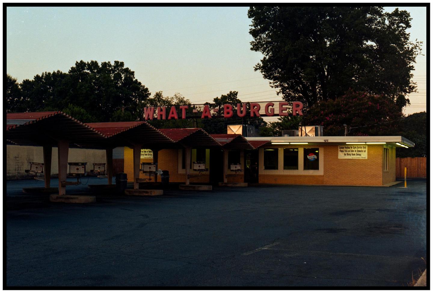 A "What-A-Burger" restaurant with car service bays is visible under a pale sky.