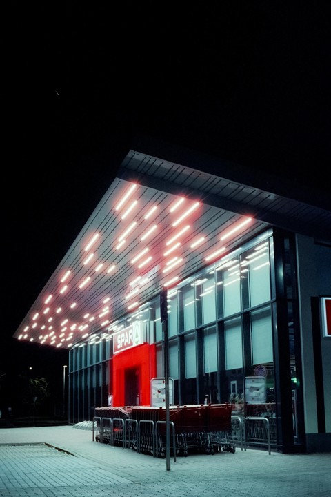 A Spar supermarket is illuminated by neon lights at night.