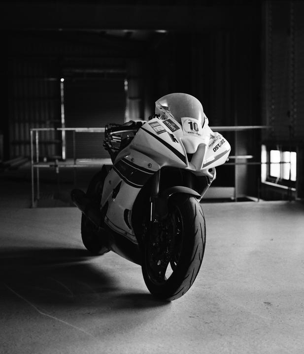 A motorcycle is parked in a dark garage.