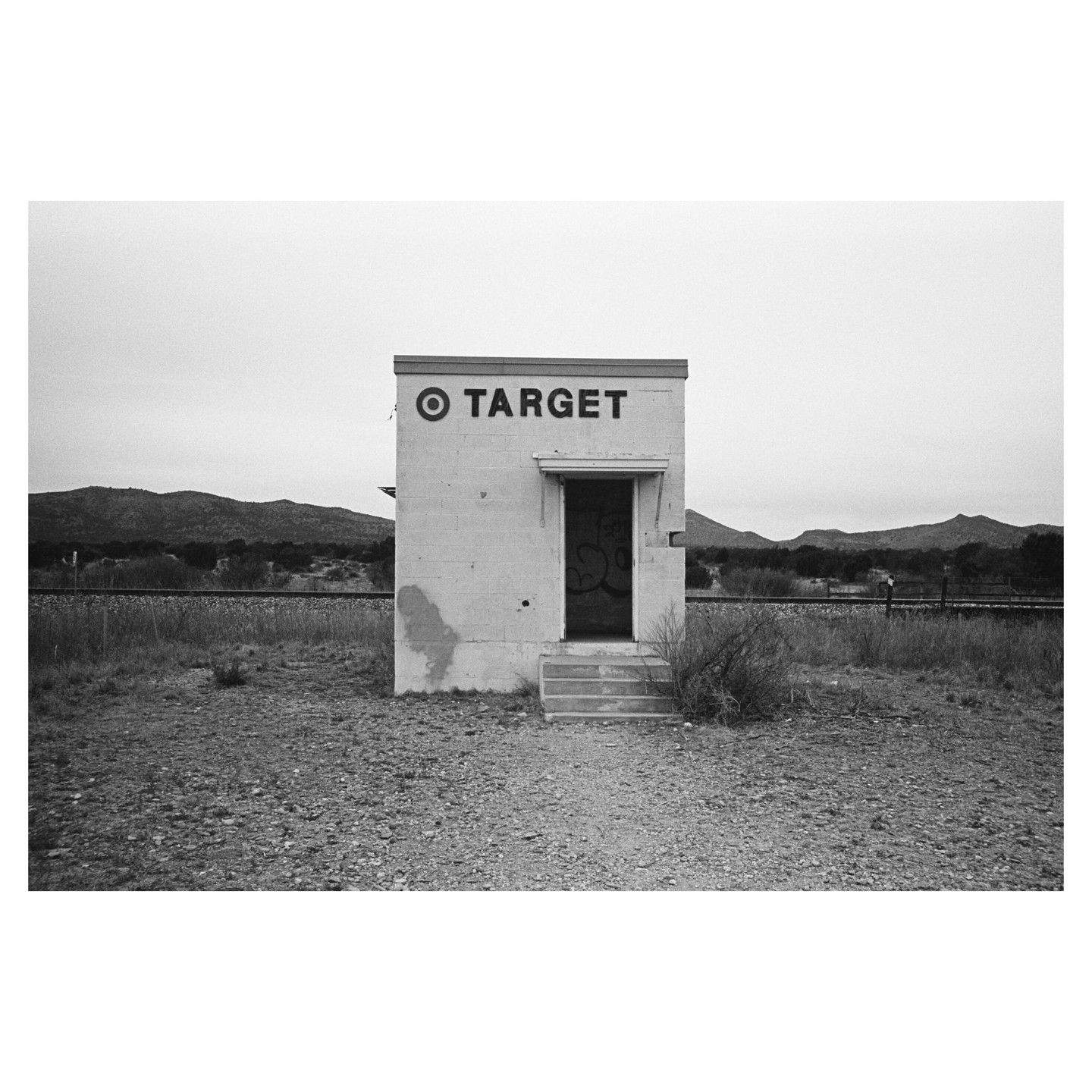 A small building with "TARGET" written on it stands in a desolate landscape with mountains in the background.