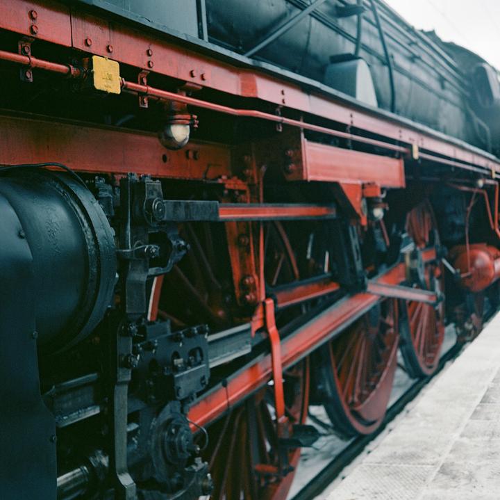 The side of a red and black steam engine with large wheels is visible.