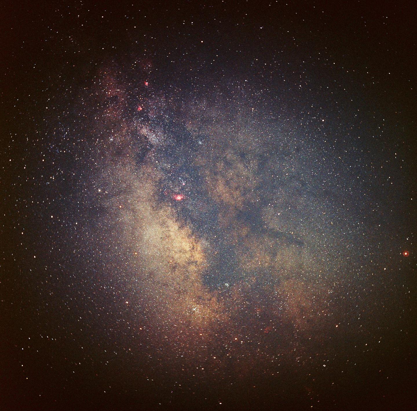The Milky Way is visible in the night sky, filled with countless stars and cosmic dust.