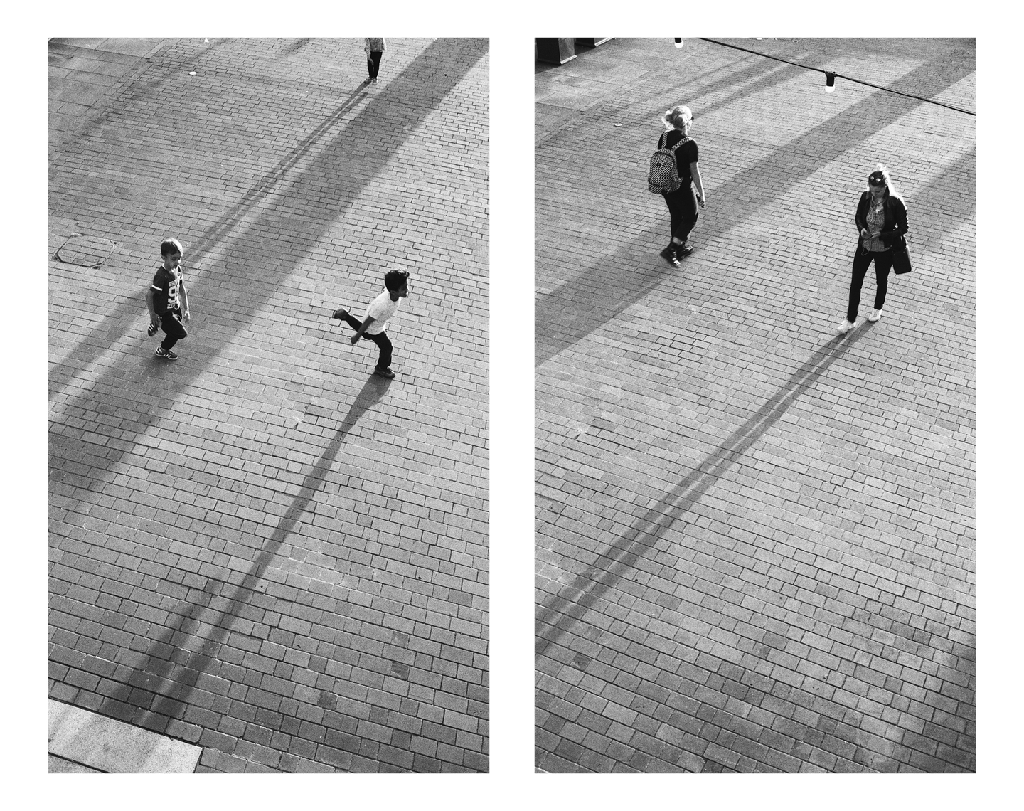 Two children and two women walk on a brick plaza, casting long shadows.