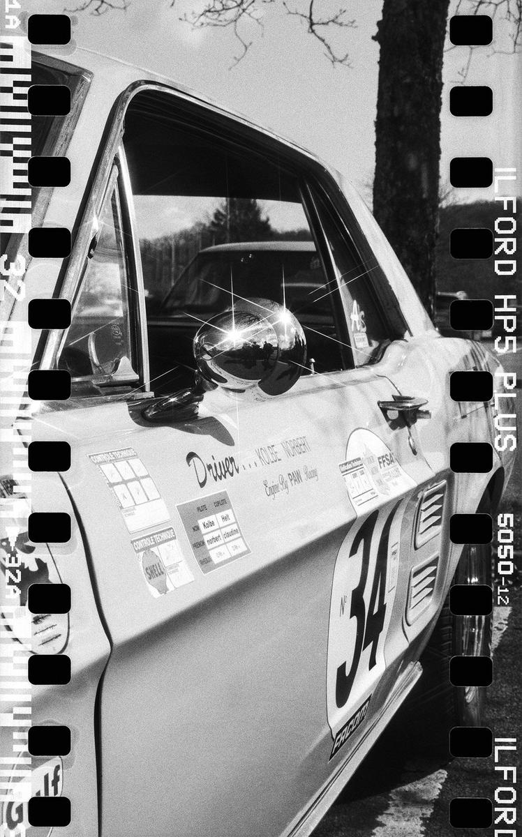 A shiny mustang with the number 34 on its side is parked outdoors.