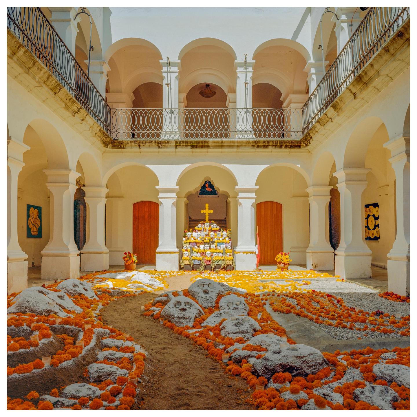 A courtyard is decorated with marigolds and sugar skulls for Day of the Dead.
