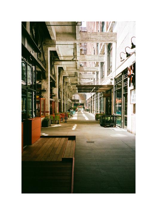 A long, covered walkway with shops and restaurants on either side stretches into the distance.