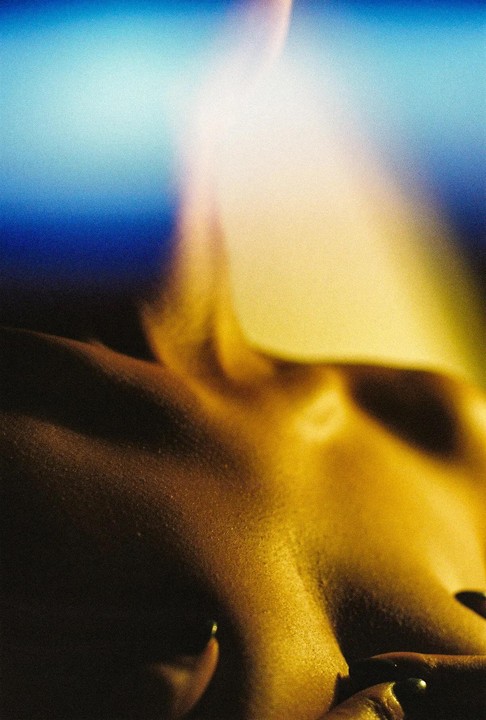 A woman's body is illuminated by a golden light with a blue background.