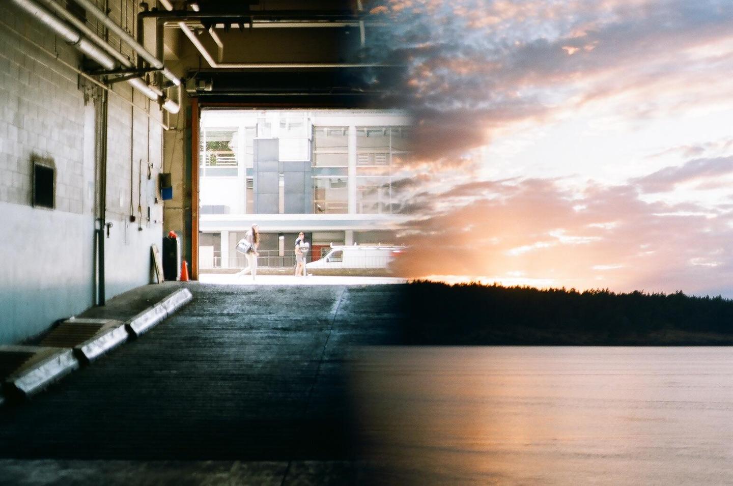 A double exposure shows a garage interior with people and a building on the left, and a sunset over a body of water and forest on the right.