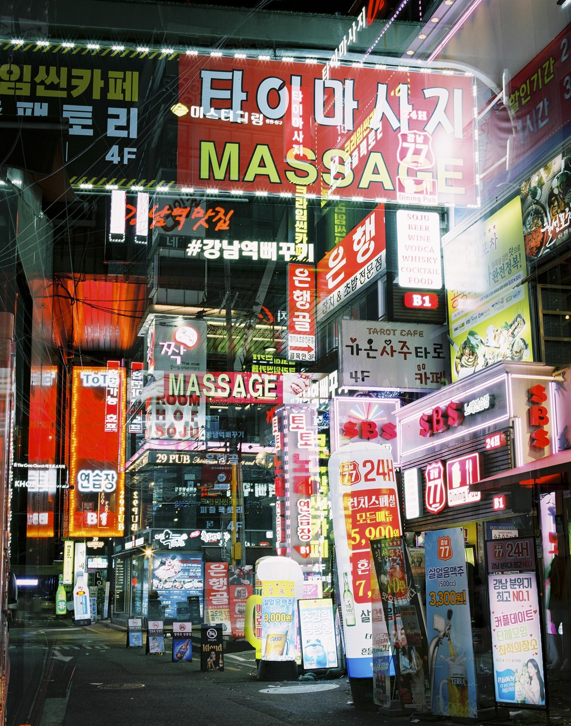 A street at night is filled with many bright neon signs and advertisements.