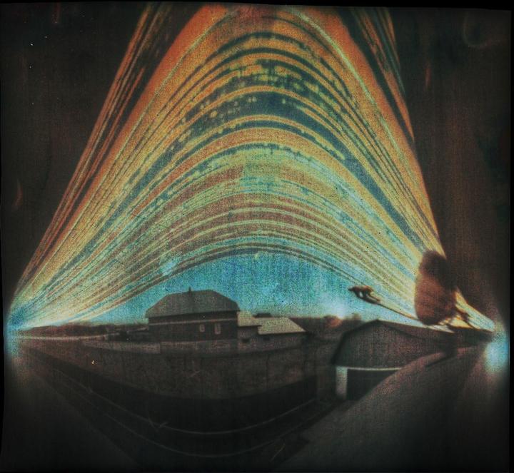 A long exposure photograph shows the sun's path as a series of arcs over a building.