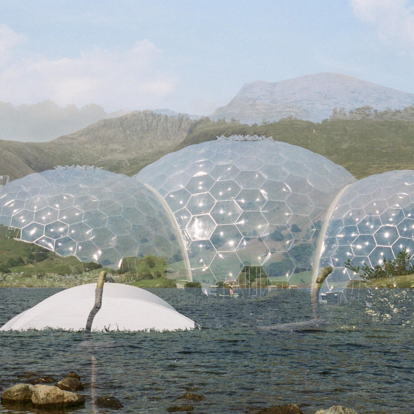 Several large geodesic domes are partially submerged in a body of water with mountains in the background.