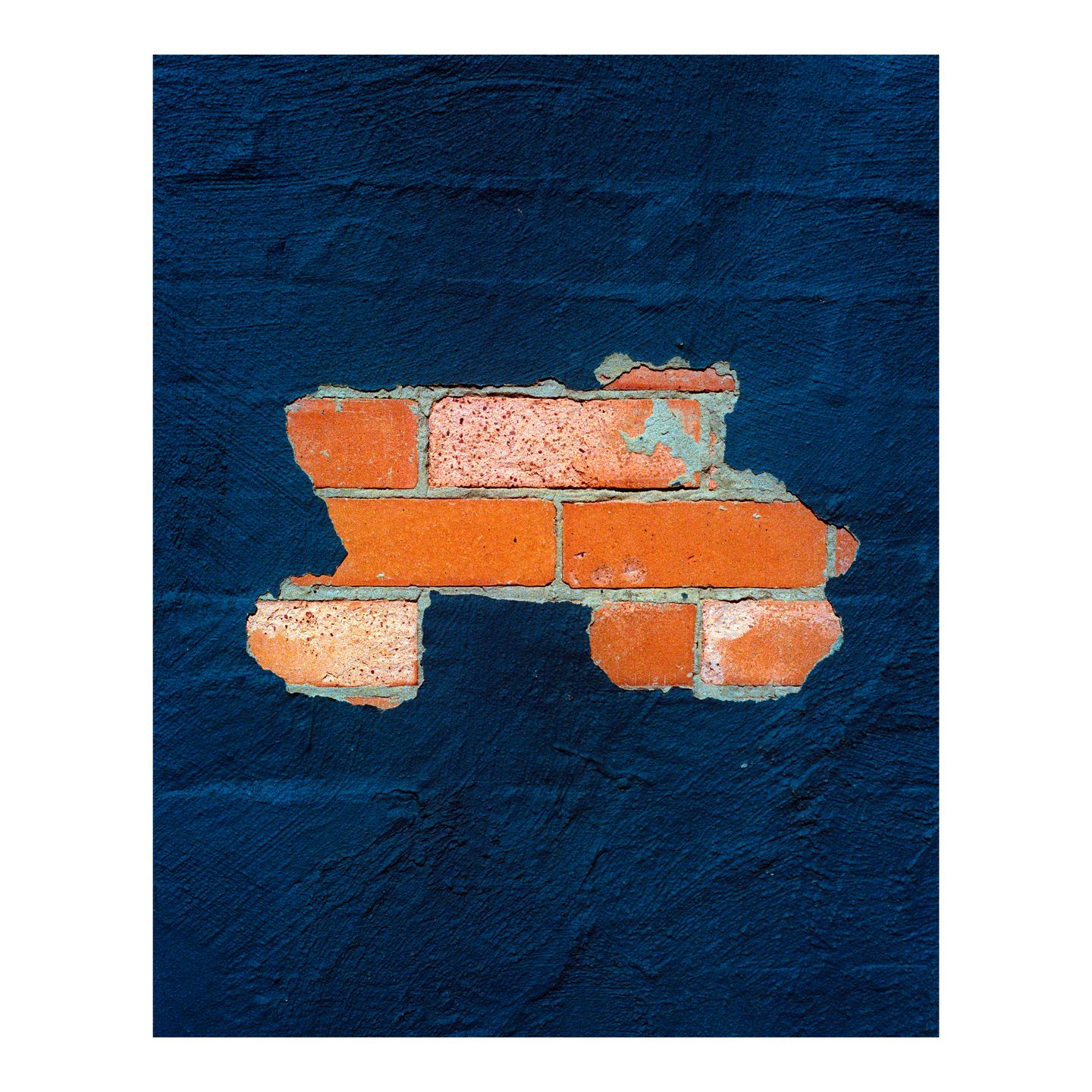A section of exposed brick wall is visible through peeling dark blue paint.