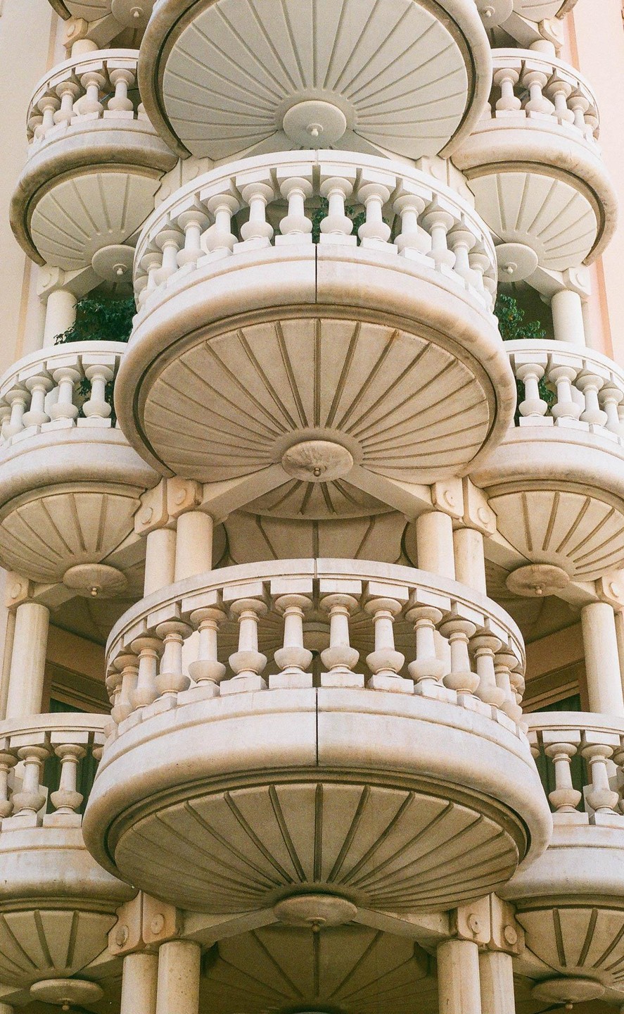 A building with multiple ornate balconies is shown from a low angle.