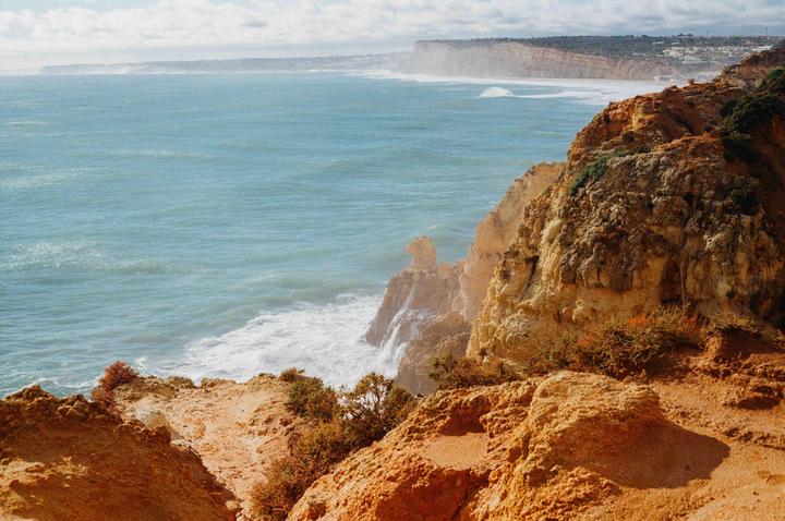 The image shows a view of the Portuguese coast with cliffs and the ocean.