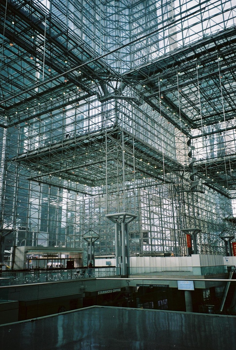 A large, modern building with a glass and metal grid structure is visible, with a Starbucks Coffee sign on a lower level.