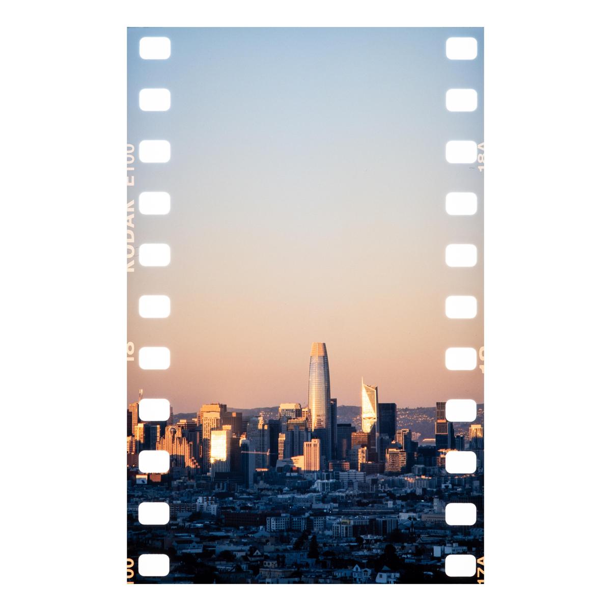 A cityscape with tall buildings is visible through a film strip border.