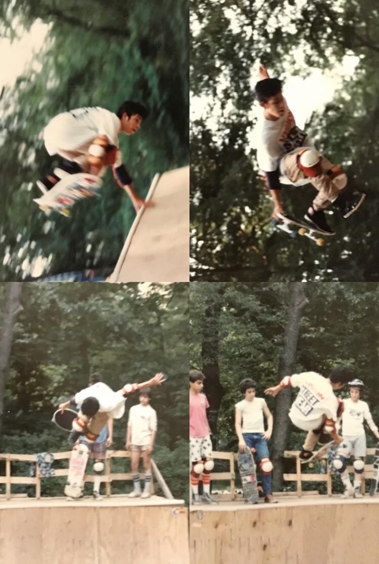 A young man skates on a homemade vert ramp while other young men watch.