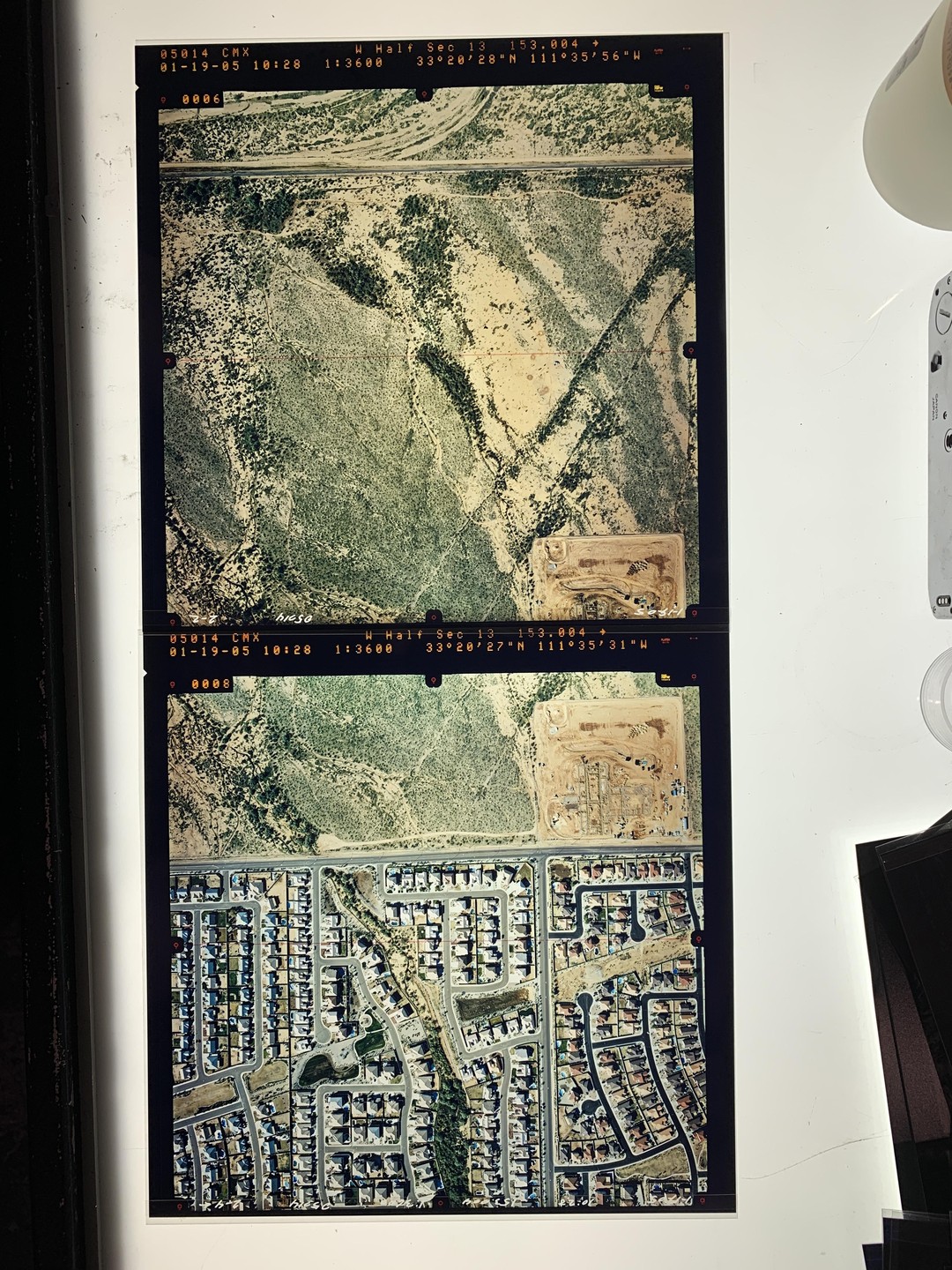 Two aerial photographs show a desert landscape before and after urban development.