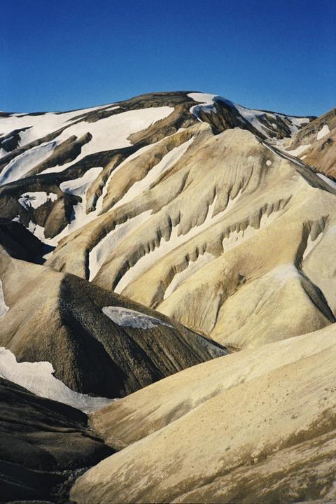 Snow covers the peaks and valleys of the colorful rhyolite mountains of Landmannalaugar.